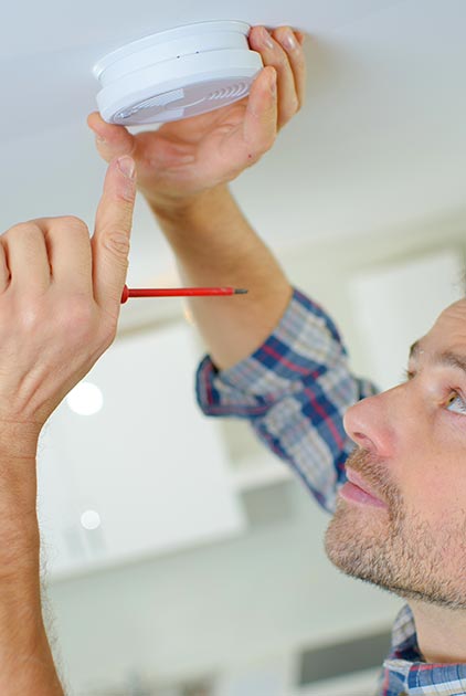 technicien installant un détecteur de fumée